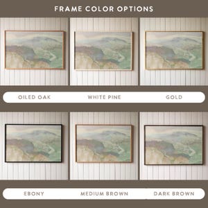 May include: A comparison of different frame colours for a framed print. The print depicts a landscape scene with a river and mountains in muted tones. The frame colours are oiled oak, white pine, gold, ebony, medium brown, and dark brown.