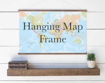 May include: A wooden shelf with a world map hanging above it in a hanging map frame. The map is blue and has brown borders. There is a small potted plant on the shelf.