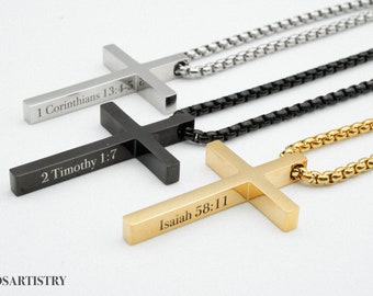 May include: Three silver, black, and gold cross necklaces with different bible verses engraved on them. The silver cross has the verse "1 Corinthians 13:4-5", the black cross has the verse "2 Timothy 1:7", and the gold cross has the verse "Isaiah 58:11".