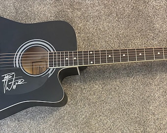 Guitarra acústica negra firmada por Dave Matthews