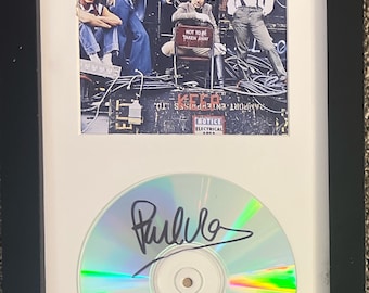 May include: Framed album cover art for "Who Are You" by The Who, with a signed CD below. The album art features the band members in a complex setting with the text "Who Are You" at the top.