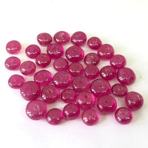 Può includere: Un gruppo di 30 perle rotonde di rubino rosa. Le perle sono lisce e hanno una leggera lucentezza.