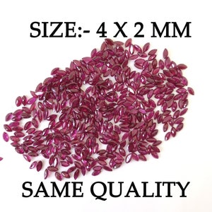 Puede incluir: Un montón de aproximadamente 100 pequeñas piedras preciosas de color rojo oscuro en forma de marquesa. Las piedras preciosas miden aproximadamente 4 mm por 2 mm. El texto "SIZE:- 4 X 2 MM" está impreso sobre las piedras preciosas. El texto "SAME QUALITY" está impreso debajo de las piedras preciosas.