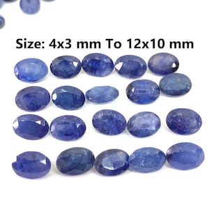 Könnte beinhalten: Eine Sammlung ovaler blauer Edelsteine, die in der Größe von 4x3 mm bis 12x10 mm reichen. Die Edelsteine sind in Reihen auf einer weißen Oberfläche angeordnet.  Größe: 4x3 mm bis 12x10 mm