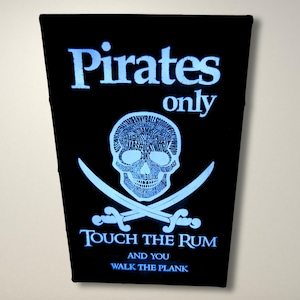 May include: A black and white sign with a skull and crossbones and the text "Pirates only Touch the Rum and you Walk the Plank".
