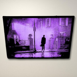 Pode incluir: Uma imagem roxa e preta de um homem caminhando por uma rua &agrave; noite. O texto "What an excellent day for an exorcism" est&aacute; na parte inferior da imagem.