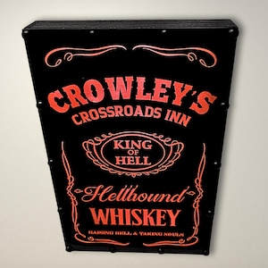 May include: Black sign with red text that reads "Crowley's Crossroads Inn", "King of Hell", "Hellhound Whiskey", and "Raising Hell & Taking Souls".