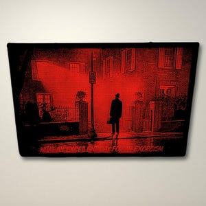 Pode incluir: Uma ilustra&ccedil;&atilde;o vermelha e preta de um homem caminhando por uma rua &agrave; noite. O texto "&Eacute; um dia excelente para um exorcismo" est&aacute; na parte inferior da imagem.