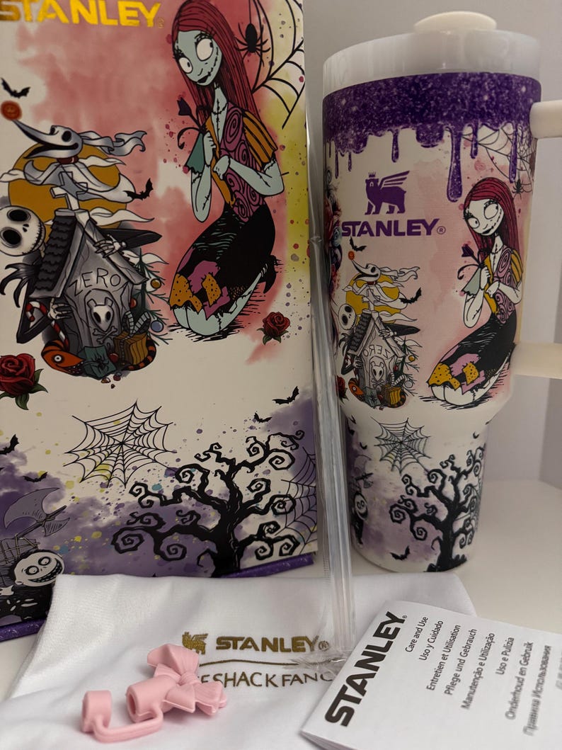 Puede incluir: Un juego de vaso y caja Stanley con Sally de Pesadilla antes de Navidad. El vaso es blanco con un dise&ntilde;o de goteo morado e ilustraciones de personajes. La caja tiene ilustraciones similares, incluyendo a Zero y una casa espeluznante. Los accesorios incluyen un asa rosa y una pajita transparente.