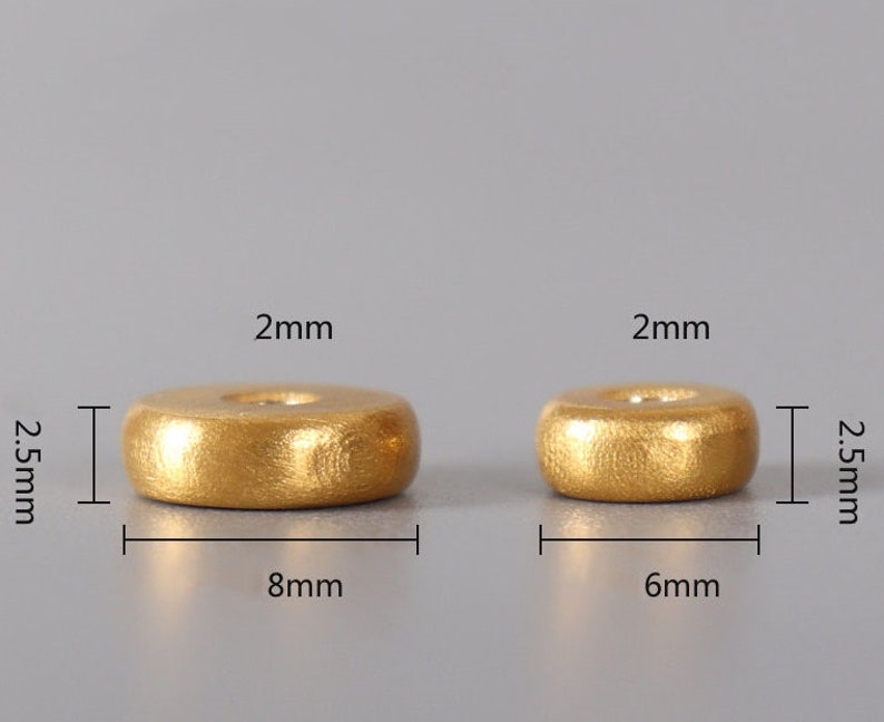 May include: Two gold-colored wooden rings, one measuring 2.5 inches in diameter and 8 mm in height, and the other measuring 2.5 inches in diameter and 6 mm in height.