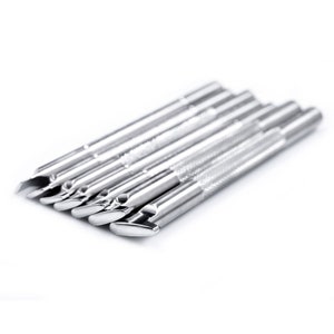 Pu&ograve; includere: Un set di otto strumenti in metallo argentato con punte di diverse forme. Gli strumenti sono disposti in fila, con le punte rivolte verso lo spettatore.