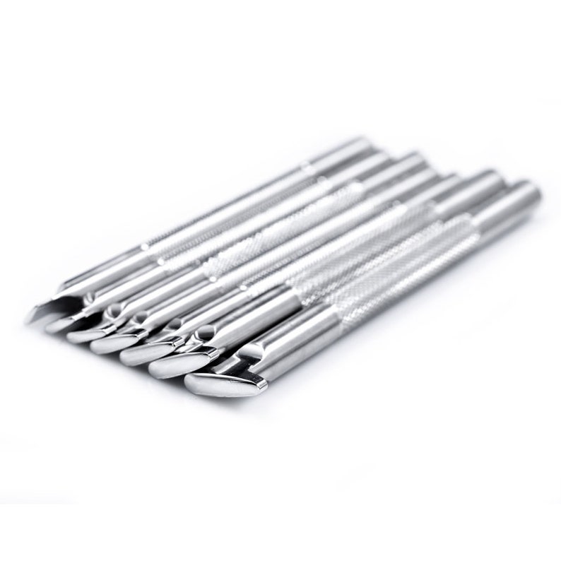 Pu&ograve; includere: Un set di otto strumenti in metallo argentato con punte di diverse forme. Gli strumenti sono disposti in fila, con le punte rivolte verso lo spettatore.