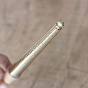 May include: A gold-toned metal ring sizer with a graduated series of rings. The sizer is designed to help determine the correct ring size.