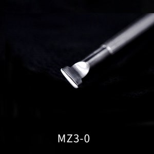 Pu&ograve; includere: Uno strumento in metallo argentato per spingere le cuticole, con una punta arrotondata. Lo strumento &egrave; su uno sfondo nero. MZ3-0