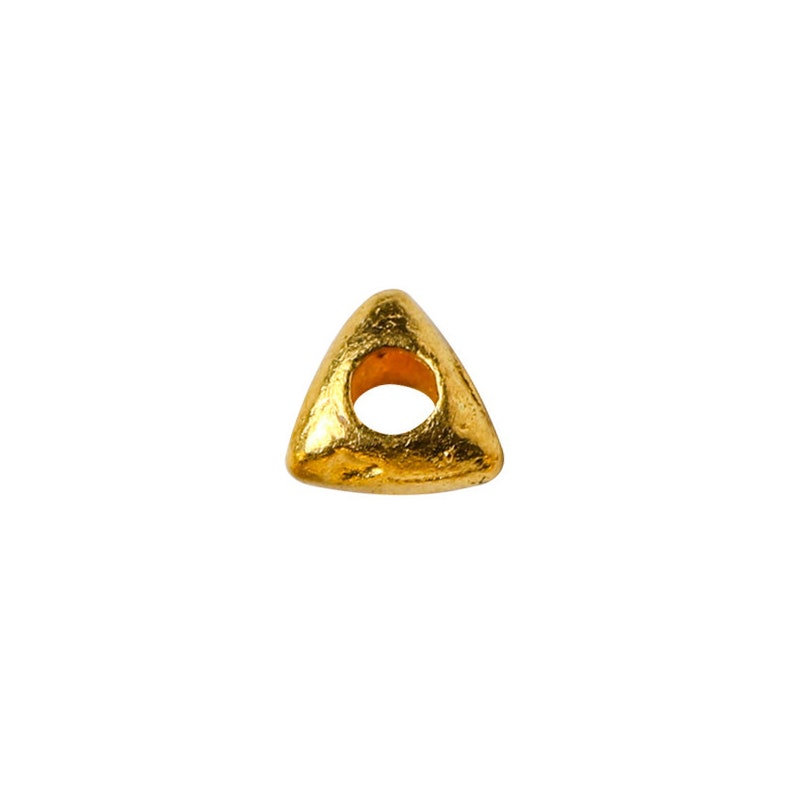 May include: Gold triangle bead with a hole in the center. The bead has a textured surface.