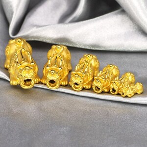 May include: A set of six gold-colored lion figurines of varying sizes. The figurines are arranged in a row from largest to smallest, with the largest figurine at the left and the smallest figurine at the right.