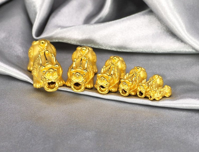 May include: A set of six gold-colored lion figurines of varying sizes. The figurines are arranged in a row from largest to smallest, with the largest figurine at the left and the smallest figurine at the right.