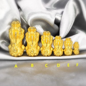 May include: Seven gold lion figurines of varying sizes, arranged in a row from largest to smallest. The figurines are all in a seated position with their paws raised. The figurines are labeled A through F.