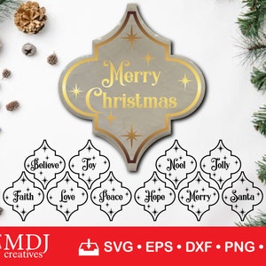 May include: Christmas-themed decorative elements. A large, ornate sign with "Merry Christmas" in gold lettering, and smaller signs with words like "Believe," "Joy," and "Santa." The design is in a neutral colour palette with gold accents.