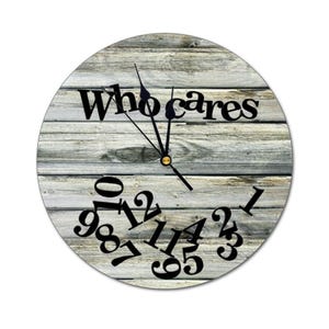 May include: A round clock with a wood grain background and the text "Who cares" printed on it. The clock numbers are scattered around the face of the clock.