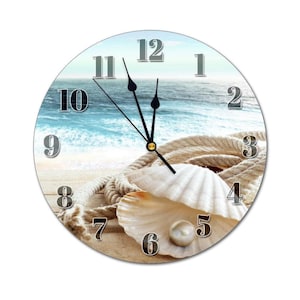 May include: A round clock with a beach scene featuring a seashell, rope, and a pearl. The clock face has black hands and white numbers.