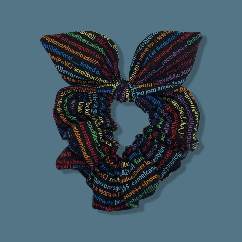 May include: A black hair scrunchie with a rainbow print of computer code. The code includes words like "upload", "download", "linked", "scrollbar", "filter", "value", "user", "style", and "now".