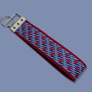 May include: Red and blue key chain with a white wavy pattern and red Mickey Mouse heads.