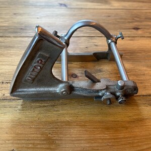 May include: A silver metal hand plane with a red "VICTOR" label on the side. The plane has a metal handle and a metal blade.