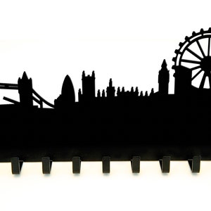 Puede incluir: Porta llaves de metal negro con forma de horizonte de Londres, con el London Eye, el Tower Bridge y el Big Ben. El soporte tiene 8 ganchos.