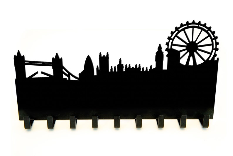Puede incluir: Porta llaves de metal negro con forma de horizonte de Londres, con el London Eye, el Tower Bridge y el Big Ben. El soporte tiene 8 ganchos.