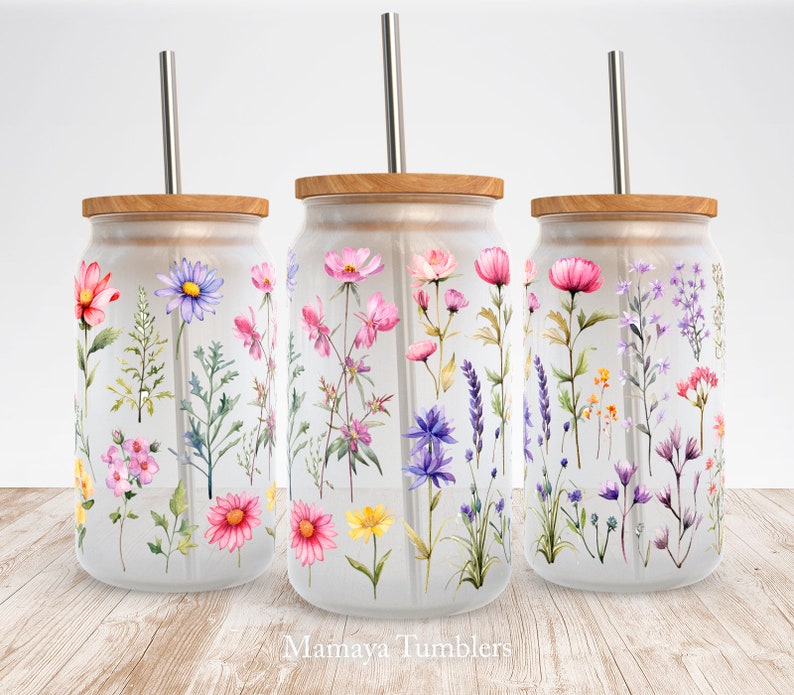 May include: Three glass tumblers with wooden lids and stainless steel straws. Each tumbler features a different watercolor floral design with pink, purple, yellow, and blue flowers.