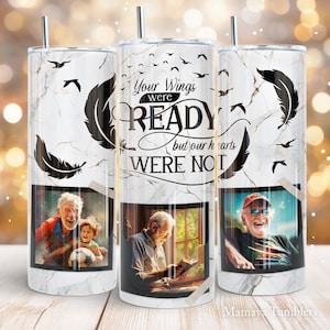May include: White marble tumbler with black feather design and the text "Your wings were ready but our hearts were not". The tumbler has a photo of a man and a boy playing with a soccer ball, a man reading a book, and a man smiling.