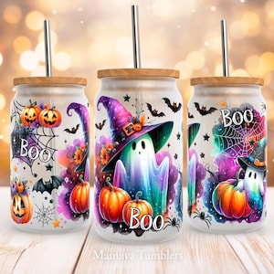 Puede incluir: Tres vasos blancos con temática de Halloween con tapas y pajitas. Los vasos presentan un fantasma con un sombrero de bruja, calabazas, murciélagos y la palabra "BOO" en un esquema de colores morado, rosa y azul.
