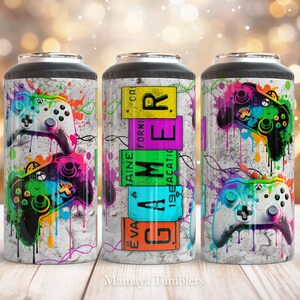 May include: Three colourful stainless steel tumblers with a gamer theme. The tumblers feature a white background with colourful paint splatters and a black and green video game controller. One tumbler has the word "GAMER" spelled out in colourful letters.