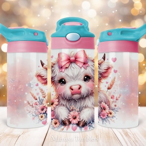 May include: A pink and blue water bottle with a cute cartoon cow with a pink bow on its head. The cow is surrounded by pink and white flowers. The bottle has a screw-on lid and a straw.
