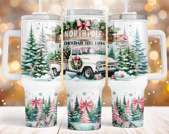 May include: White tumbler with a Christmas tree farm design. The tumbler features a vintage truck with a wreath, pink bows, and the text "North Pole Christmas Tree Farm Always Fresh".