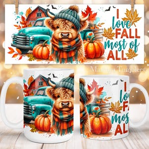 Puede incluir: Una taza de cerámica blanca con una ilustración colorida de una vaca de las Tierras Altas que lleva un sombrero azul y blanco y una bufanda. La vaca está de pie frente a una camioneta azul con un granero rojo en el fondo. La taza tiene el texto "Me encanta el otoño más que nada" en letras azul verdoso y rojas.