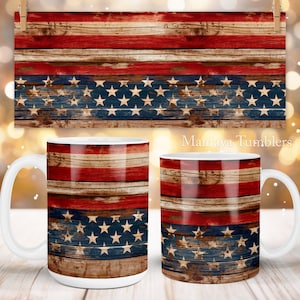 May include: Two white ceramic mugs with a wood grain design featuring the American flag colors of red, white, and blue. The mugs are on a wooden surface.  Mamaya Tumblers.