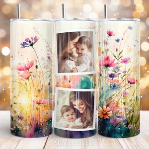Op de afbeelding: Een set van drie roestvrijstalen bekers. Twee bekers hebben een aquarel bloemenontwerp met roze, paarse en gele bloemen. De middelste beker heeft twee fotolijsten met afbeeldingen van een moeder en kind. De tekst "Mamaya Tumblers" staat onderaan.