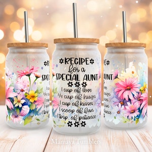 Peut inclure: Trois gobelets en verre transparent avec des couvercles en bois et des pailles en acier inoxydable. Chaque gobelet est décoré d'un motif floral et du texte "*RECIPE* for a SPECIAL AUNT *** 1 cup of love 3/4 cup of hugs 1 cup of kisses 1 scoop of fun 1 tbsp. of patience *** Mamaya Tumblers".