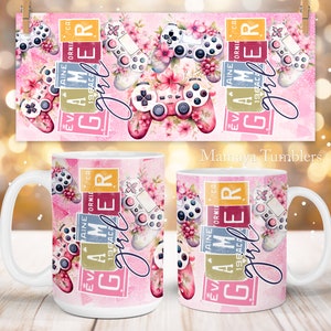 Puede incluir: Taza de cerámica blanca con fondo rosa y un diseño de un mando de videojuego con flores. El texto "I AM A GAMER girl" está escrito en la taza en una fuente rosa y amarilla.