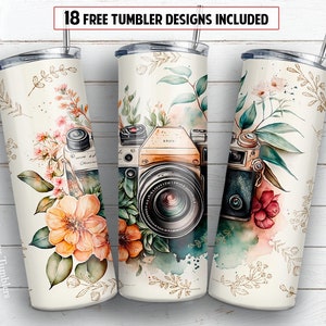 May include: Three stainless steel tumblers with floral and camera designs. The tumblers are white with gold accents and feature watercolor-style illustrations of flowers, leaves, and a vintage camera. The text "Mamaya Tumblers" is printed on the left tumbler.