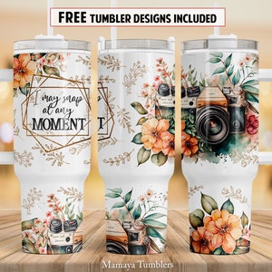 Puede incluir: Un vaso de acero inoxidable blanco con un diseño floral y un gráfico de cámara. El vaso tiene un asa y una pajita. El texto "I may snap at any MOMENT" está impreso en el vaso.