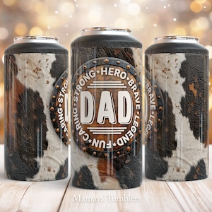 May include: A stainless steel tumbler with a brown and white cowhide pattern. The tumbler has a black lid and a silver band around the middle. The tumbler has a white circle with the words "DAD", "CARING", "STRONG", "HERO", "BRAVE", "LEGEND", and "FUN" around the circle.