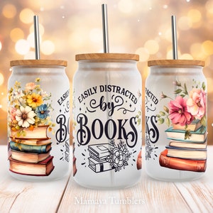 May include: Three white tumblers with a wood lid and a metal straw. Each tumbler has a different floral design and the text "Easily Distracted by Books".