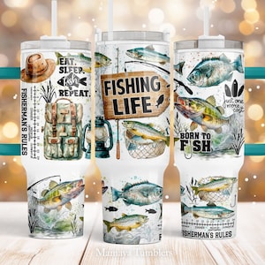 May include: A white stainless steel tumbler with a teal handle. The tumbler features a fishing theme with images of fish, fishing rods, a fishing net, and a lantern. The text "Fishing Life" and "Born to Fish" are printed on the tumbler. The tumbler also has a ruler printed on the side with the text "Fisherman's Rules".
