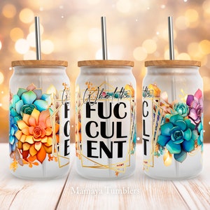 May include: Three frosted glass tumblers with bamboo lids and metal straws. Each tumbler features a colorful succulent design and the text "What the Fuculent" in a gold geometric frame. The tumblers are perfect for cold beverages.