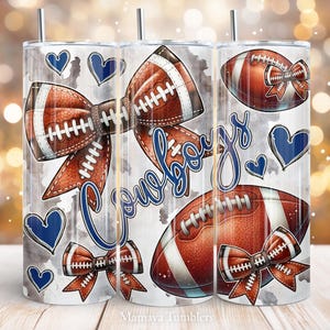 May include: Three stainless steel tumblers with a football theme. Each tumbler features a football bow, footballs, and blue hearts on a gray and white background. The word "Cowboys" is written in blue script.