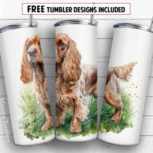 Puede incluir: Tres vasos blancos con una ilustración de acuarela de un perro Cocker Spaniel marrón y blanco de pie en la hierba verde. El perro está mirando hacia adelante en el vaso del centro, mirando hacia la izquierda en el vaso de la izquierda y mirando hacia atrás en el vaso de la derecha. Los vasos tienen una tapa plateada y una pajita plateada.