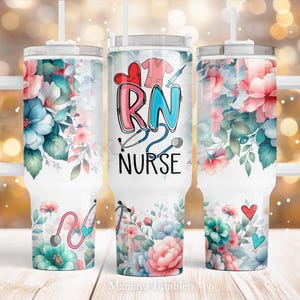 May include: Three stainless steel tumblers with floral designs and a white handle. The centre tumbler has the words "RN NURSE" in colourful letters with a stethoscope and a heart.